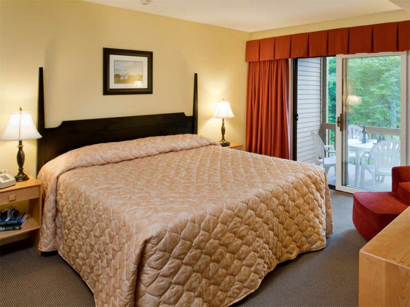 Relax in the master bedroom of our Deluxe Suite with private bath & patio or deck
